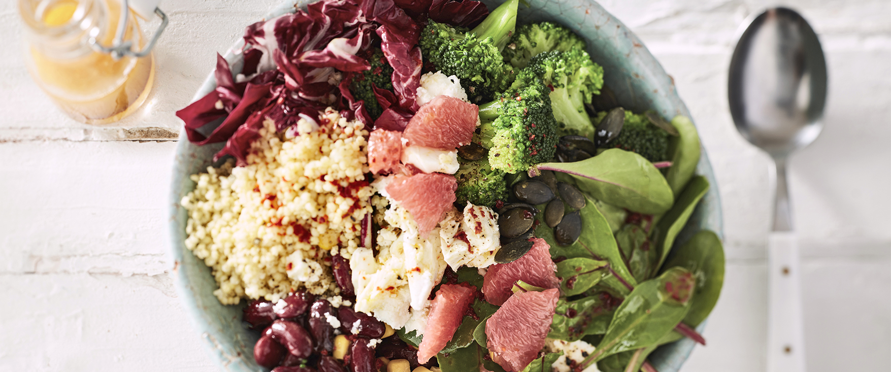 Hirse-Bowl mit Bohnen, Mais, Mangold, Brokkoli, Grapefruit und Feta