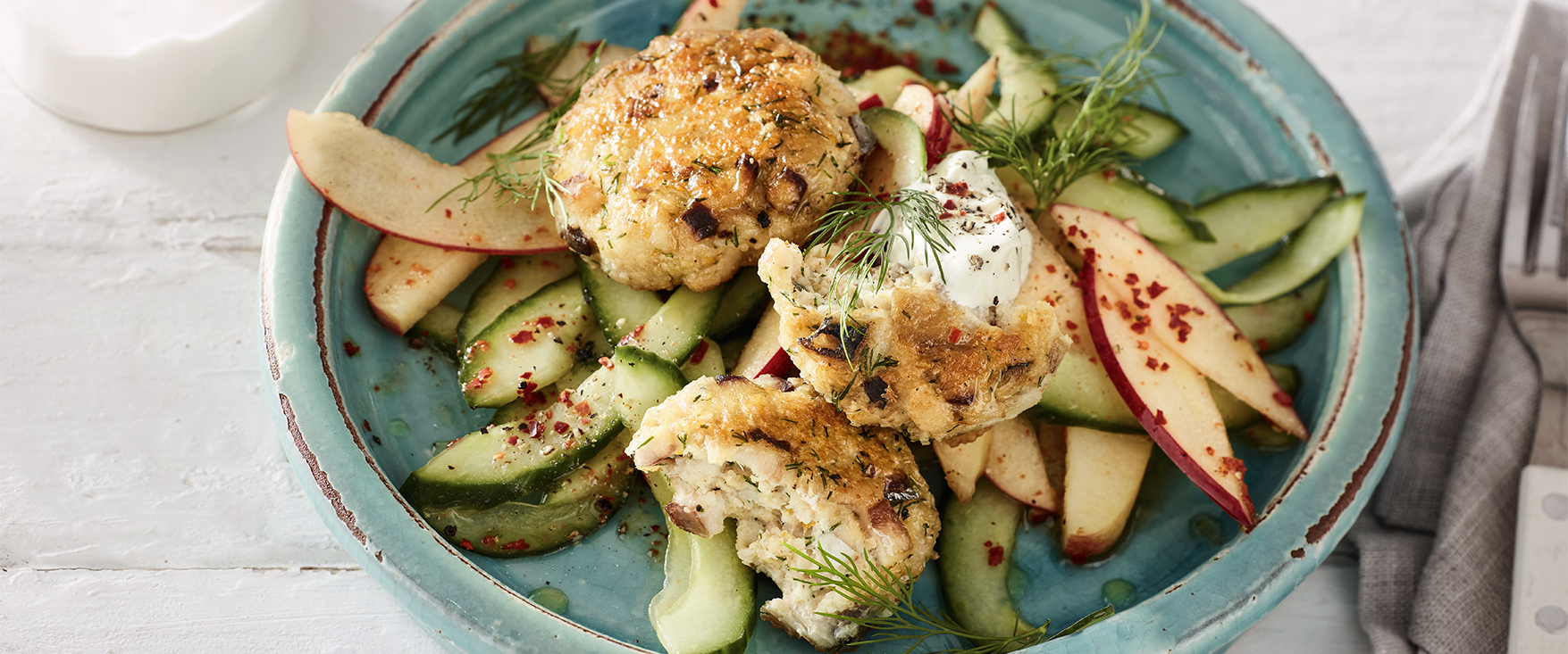 Fischfrikadellen mit Apfel-Gurken-Salat und saurer Sahne